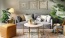 Spacious and well lit living room with wood flooring, large windows and open access to the kitchen.